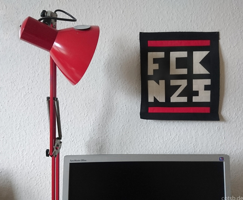 Patchwork an de Wand gepinnt, daneben eine rote Lampe